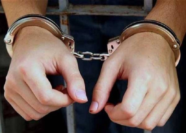 يد شخص مقيدة بالأصفاد الحديدية بعد القبض عليه.